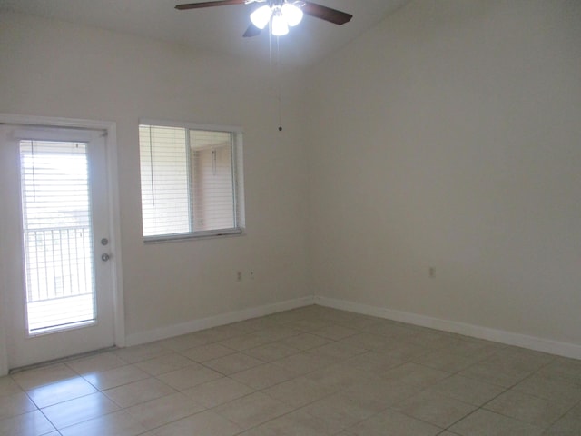 empty room with vaulted ceiling, light tile patterned flooring, ceiling fan, and baseboards