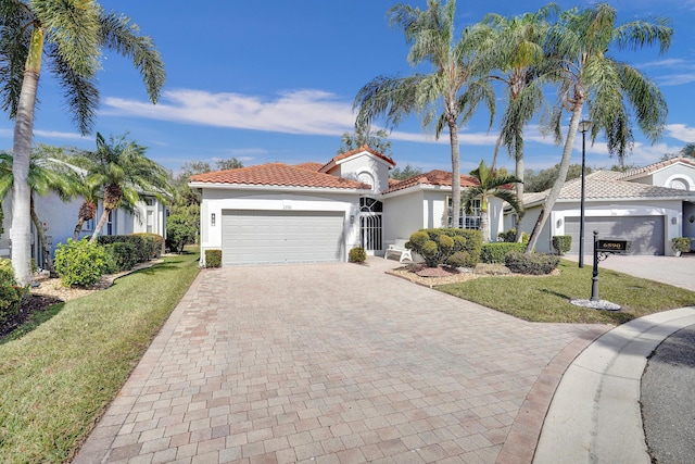 mediterranean / spanish home featuring a garage and a front lawn