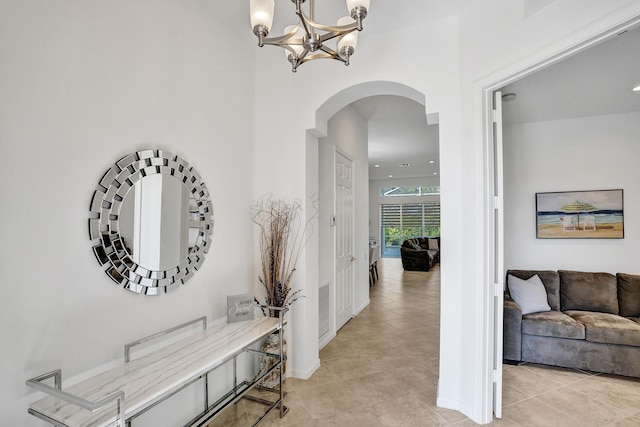 hallway featuring light tile patterned floors and an inviting chandelier