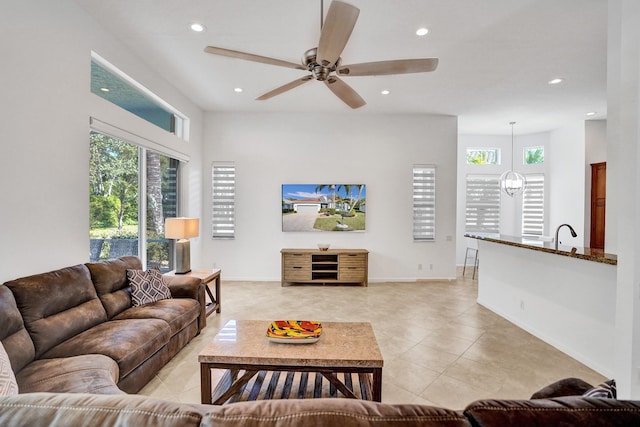 living room with light tile patterned floors and ceiling fan with notable chandelier