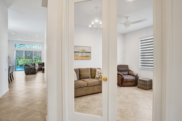 interior space featuring ceiling fan with notable chandelier and light tile patterned floors