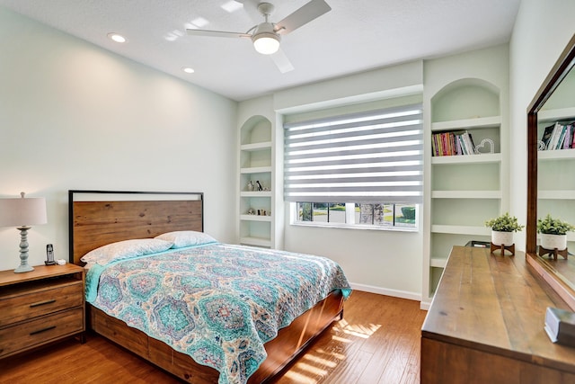 bedroom with a textured ceiling, ceiling fan, and hardwood / wood-style flooring