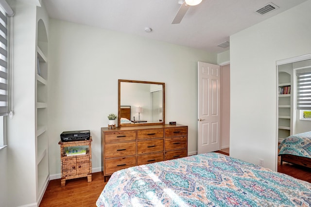 bedroom featuring a spacious closet, ceiling fan, and hardwood / wood-style flooring