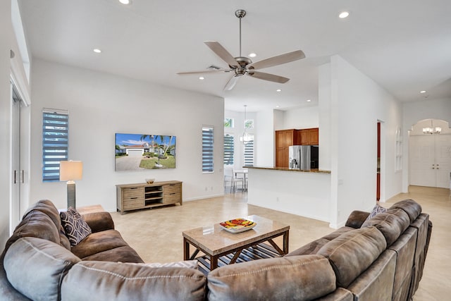 living room featuring ceiling fan with notable chandelier