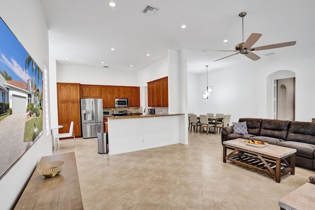 living room with ceiling fan and a towering ceiling