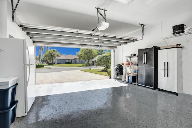 garage featuring a garage door opener and white refrigerator