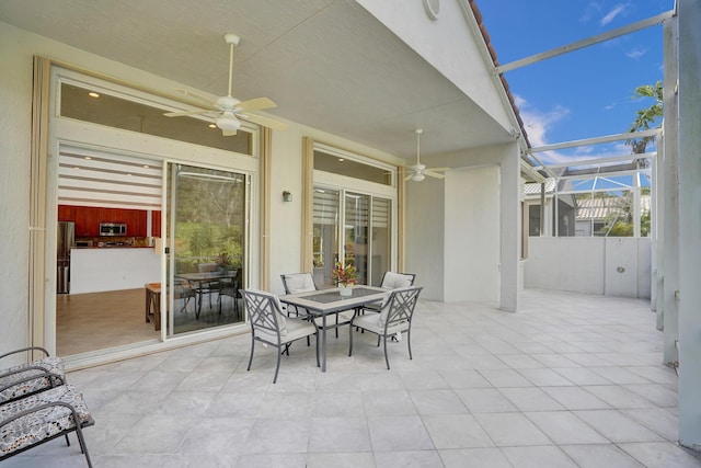 view of patio / terrace featuring ceiling fan and glass enclosure