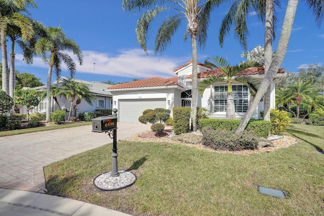 mediterranean / spanish-style home with a front yard and a garage