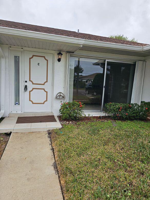 view of exterior entry featuring a yard