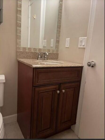 1235 S Lakes End Dr Unit 0, Fort Pierce, FL 34982 - bathroom with toilet, vanity, tile patterned flooring, and baseboards