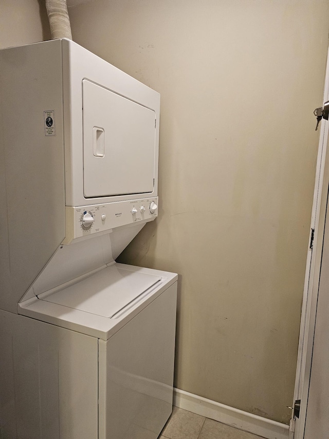 1235 S Lakes End Dr Unit 0, Fort Pierce, FL 34982 - clothes washing area with stacked washing machine and dryer, light tile patterned floors, and baseboards