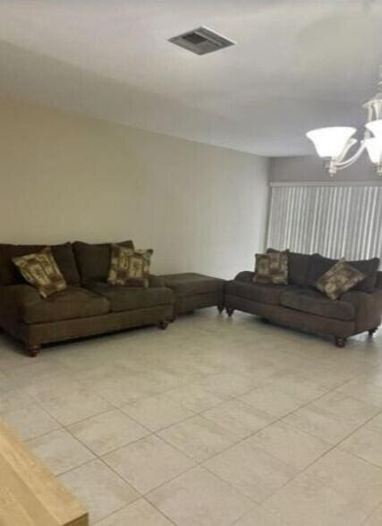 1235 S Lakes End Dr Unit 0, Fort Pierce, FL 34982 - living area with a chandelier and light tile patterned floors