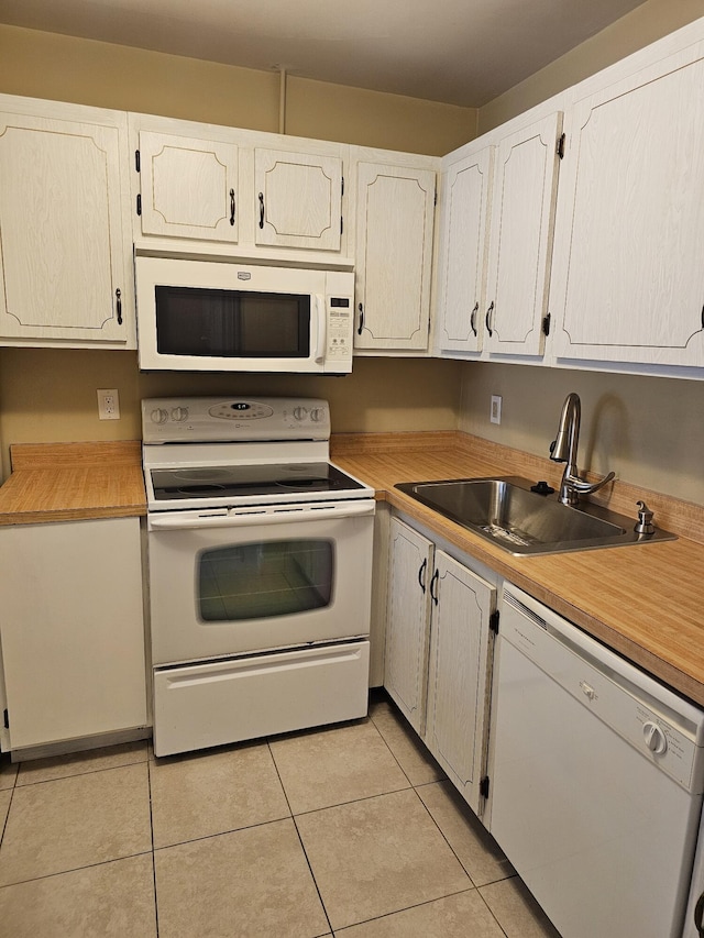 kitchen featuring light tile patterned flooring, sink, white cabinetry, and white appliances