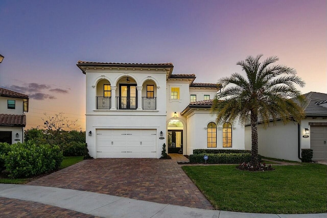 mediterranean / spanish-style home featuring a yard and a balcony