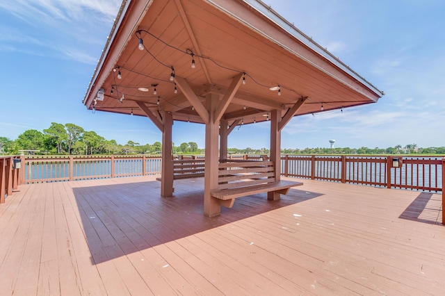 wooden deck featuring a water view and a gazebo