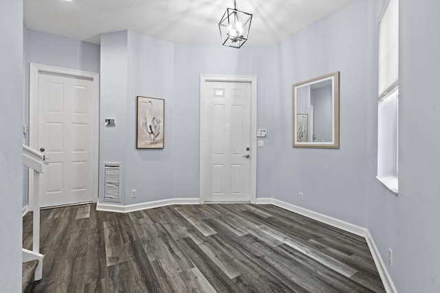 foyer featuring an inviting chandelier and dark hardwood / wood-style floors