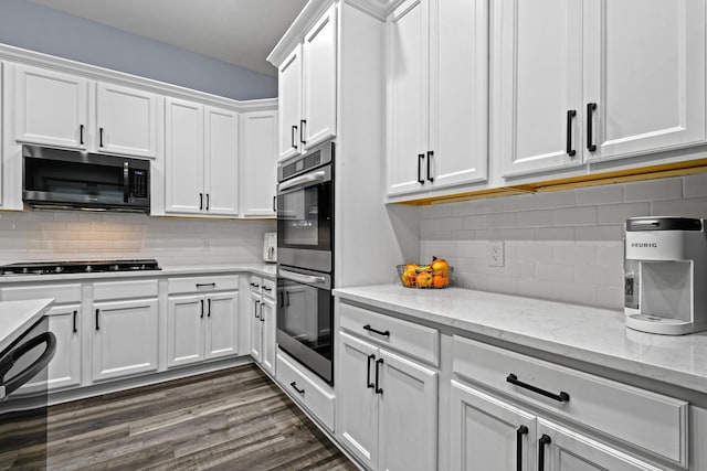 kitchen featuring light stone counters, dark hardwood / wood-style flooring, stainless steel double oven, black gas stovetop, and white cabinets