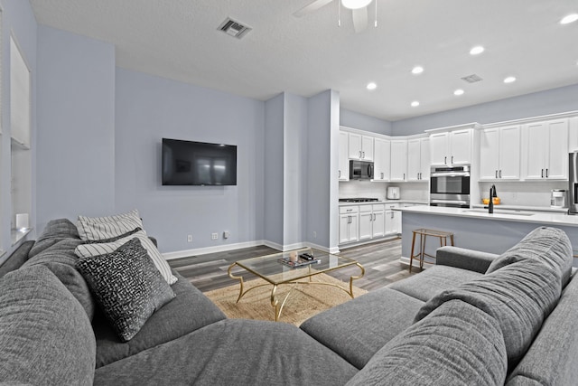 living room with sink, hardwood / wood-style floors, and ceiling fan