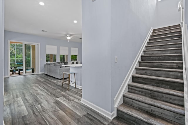 stairs featuring wood-type flooring and ceiling fan