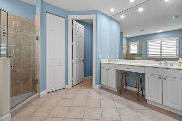 bathroom with tile patterned flooring, vanity, and walk in shower