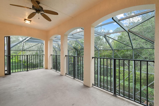 view of patio featuring ceiling fan and glass enclosure