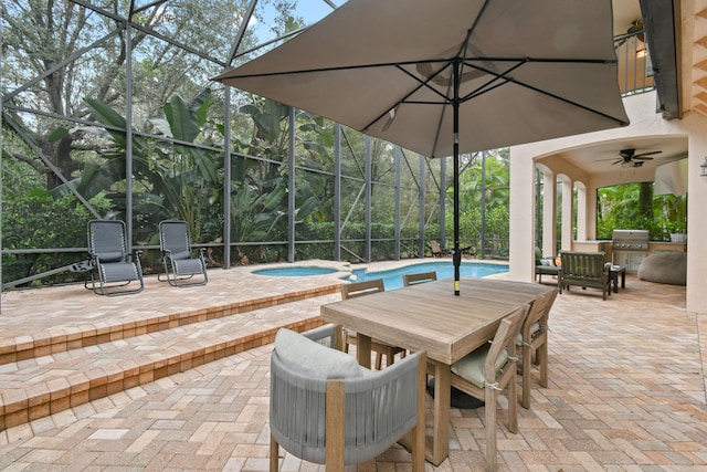 view of patio / terrace featuring ceiling fan, area for grilling, a swimming pool with hot tub, and a lanai