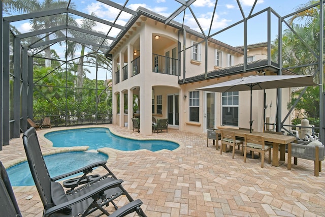 view of pool with a patio area and glass enclosure