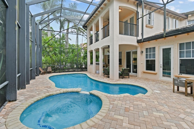 view of pool with an in ground hot tub, a lanai, and a patio area