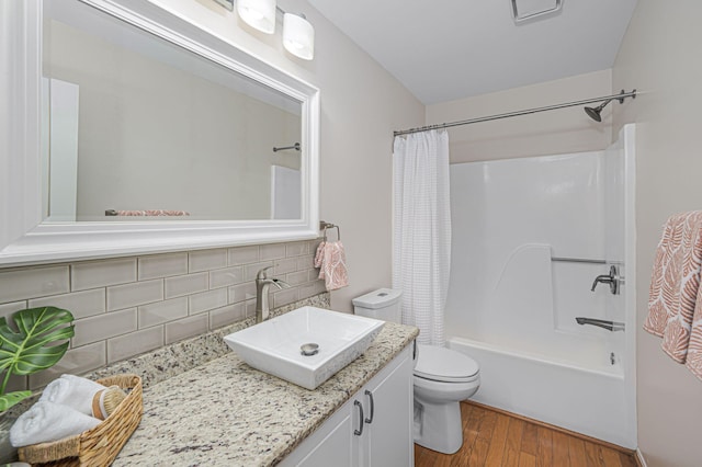 full bathroom with toilet, hardwood / wood-style floors, backsplash, shower / tub combo, and vanity