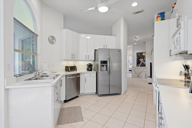 kitchen featuring sink, white cabinetry, light tile patterned floors, and stainless steel appliances