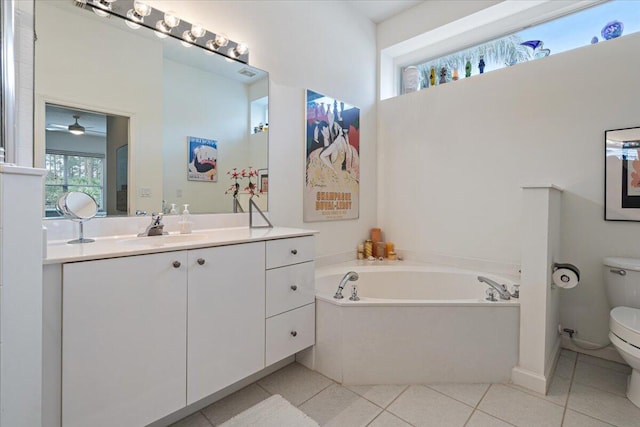 bathroom with tile patterned floors, vanity, a tub, toilet, and ceiling fan