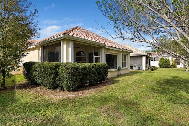 exterior space featuring a sunroom and a yard