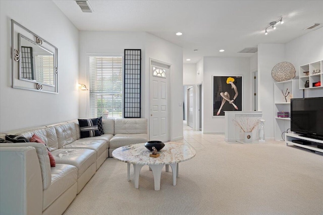 living room with rail lighting and light colored carpet