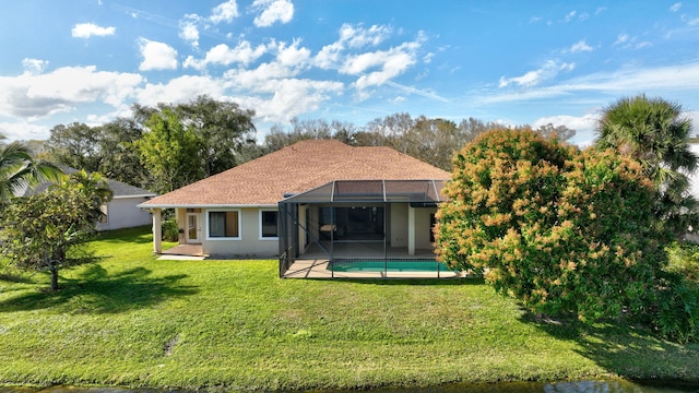 rear view of house featuring a lanai and a lawn