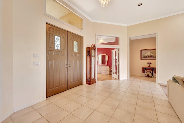 foyer with ornamental molding and light tile patterned floors