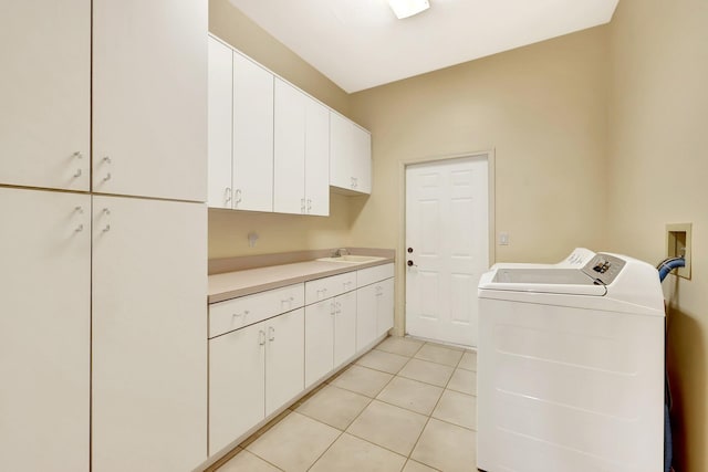 laundry area with light tile patterned flooring, cabinets, separate washer and dryer, and sink