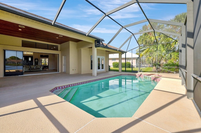 view of pool with a patio area and glass enclosure