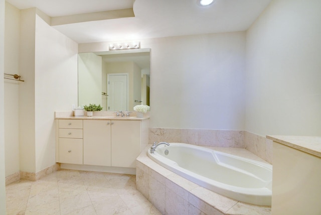 bathroom with a relaxing tiled tub and vanity