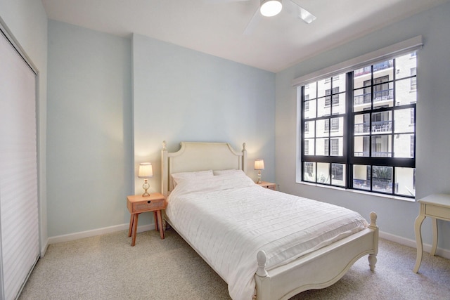 bedroom featuring ceiling fan, light colored carpet, and a closet