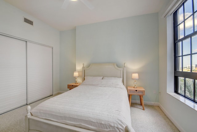 carpeted bedroom featuring ceiling fan and a closet