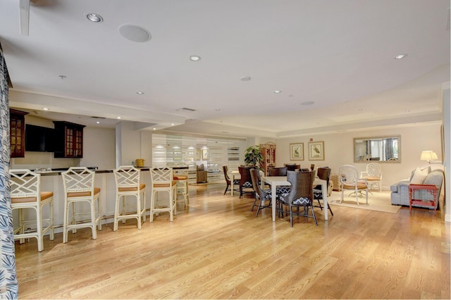 dining area with light hardwood / wood-style flooring and a tray ceiling