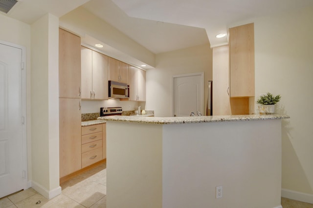 kitchen featuring kitchen peninsula, stainless steel appliances, light tile patterned floors, light brown cabinetry, and light stone counters