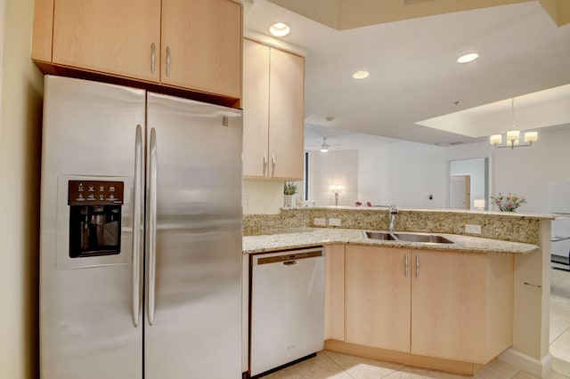 kitchen with kitchen peninsula, sink, light brown cabinets, and stainless steel appliances