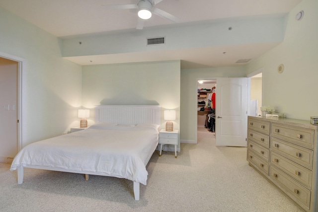 carpeted bedroom with ceiling fan, a walk in closet, and a closet