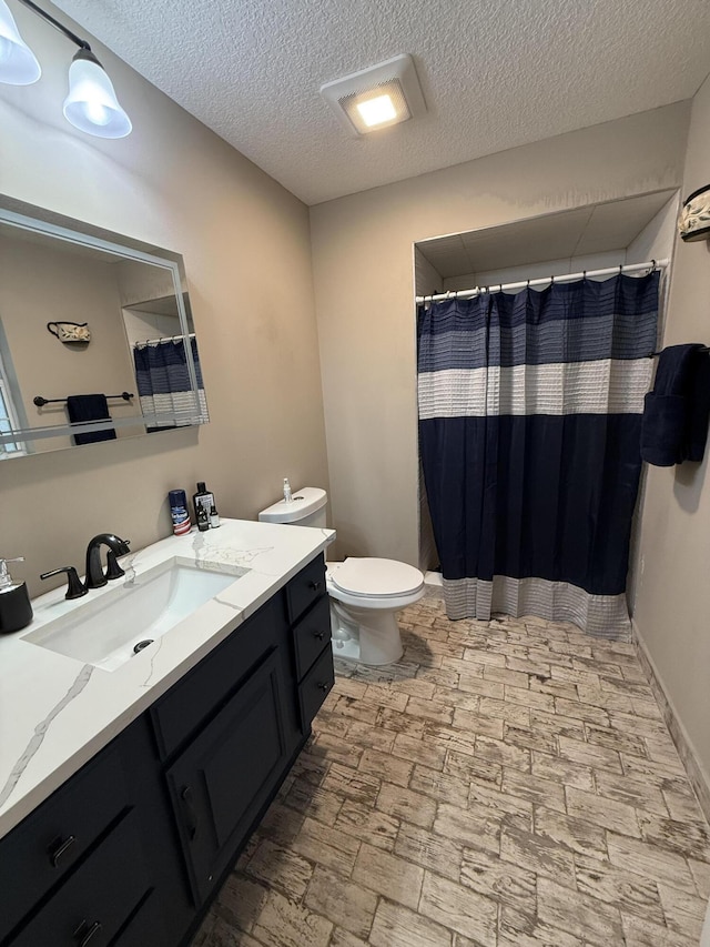 bathroom featuring a textured ceiling, toilet, vanity, and a shower with curtain