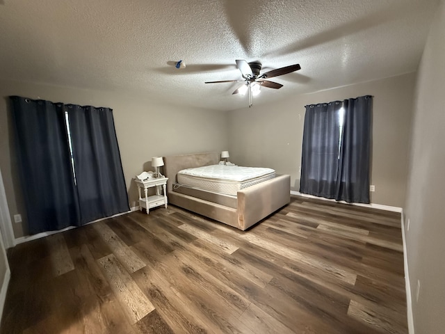 unfurnished bedroom with a textured ceiling, ceiling fan, and dark hardwood / wood-style flooring