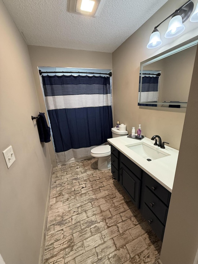 bathroom featuring toilet, vanity, a shower with shower curtain, and a textured ceiling