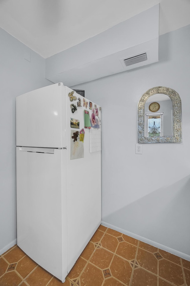 kitchen with white refrigerator and tile patterned flooring