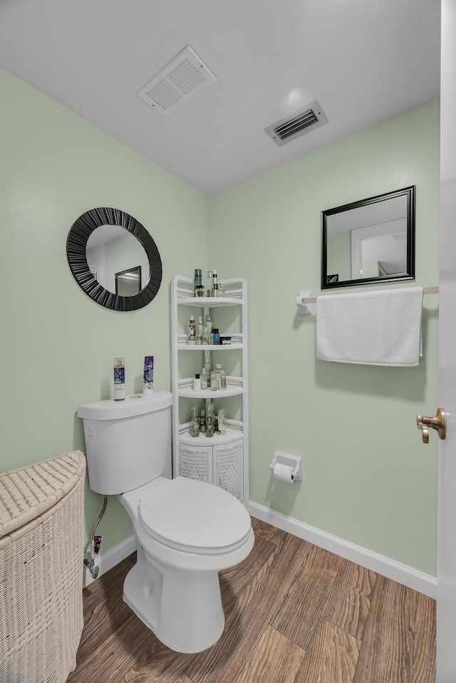 bathroom with toilet and hardwood / wood-style floors