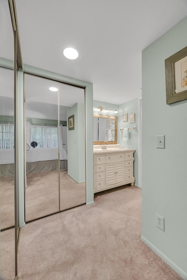 unfurnished bedroom with light colored carpet and sink